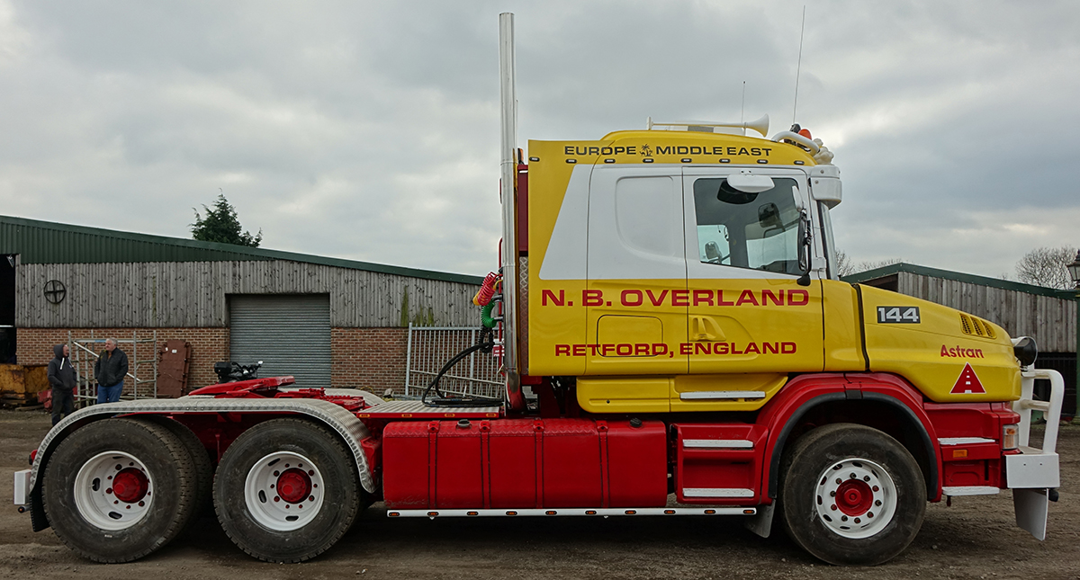 Camion rouge avec porte-engin 3 essieux et pelleteuse LANNEN – SCANIA S 6x4